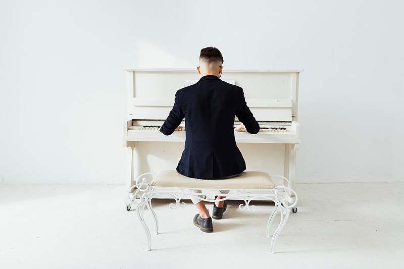 Файл:Rear-view-man-playing-piano-sitting-against-white-wall 23-2148047576.jpg