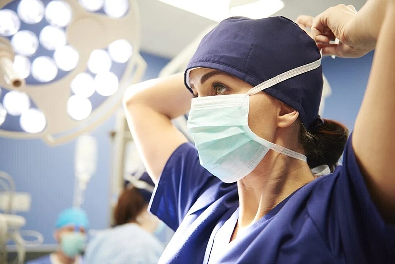 Файл:Side-view-of-young-female-surgeon-tying-her-surgical-mask.jpg