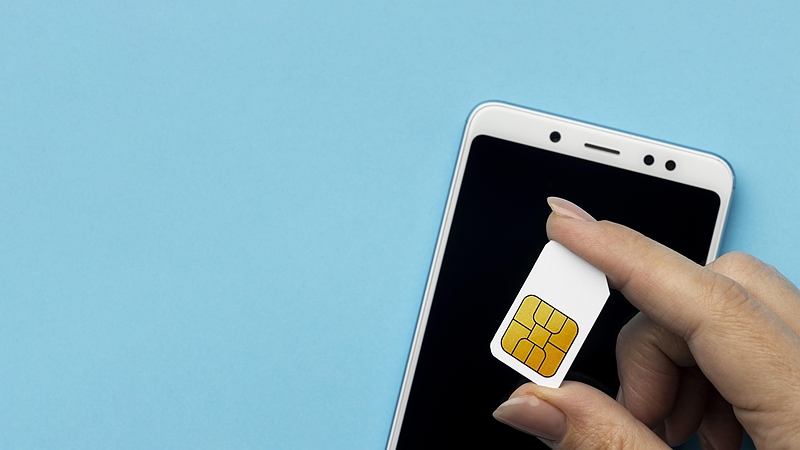 Файл:Top-view-hand-holding-sim-card-with-smartphone-copy-space.jpg